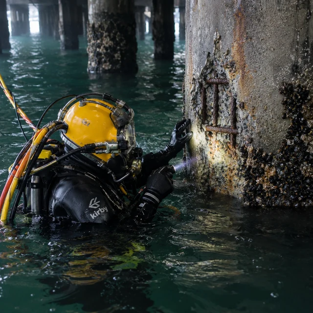 Commercial diver inspecting a concrete marine pile