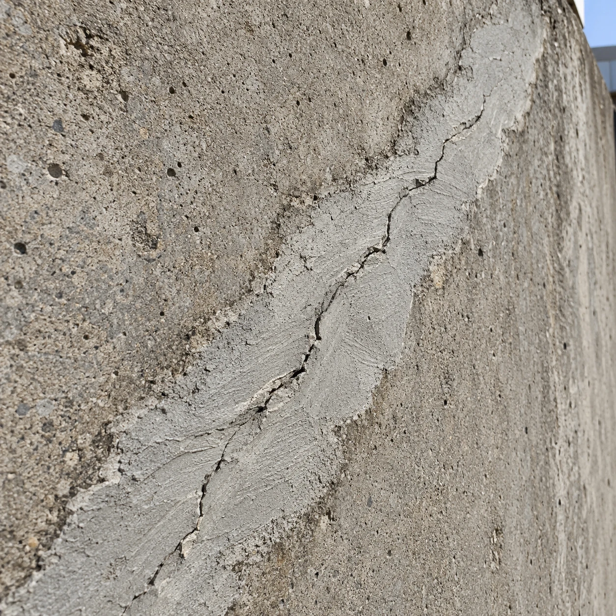 Crack reopening through an earlier concrete repair patch